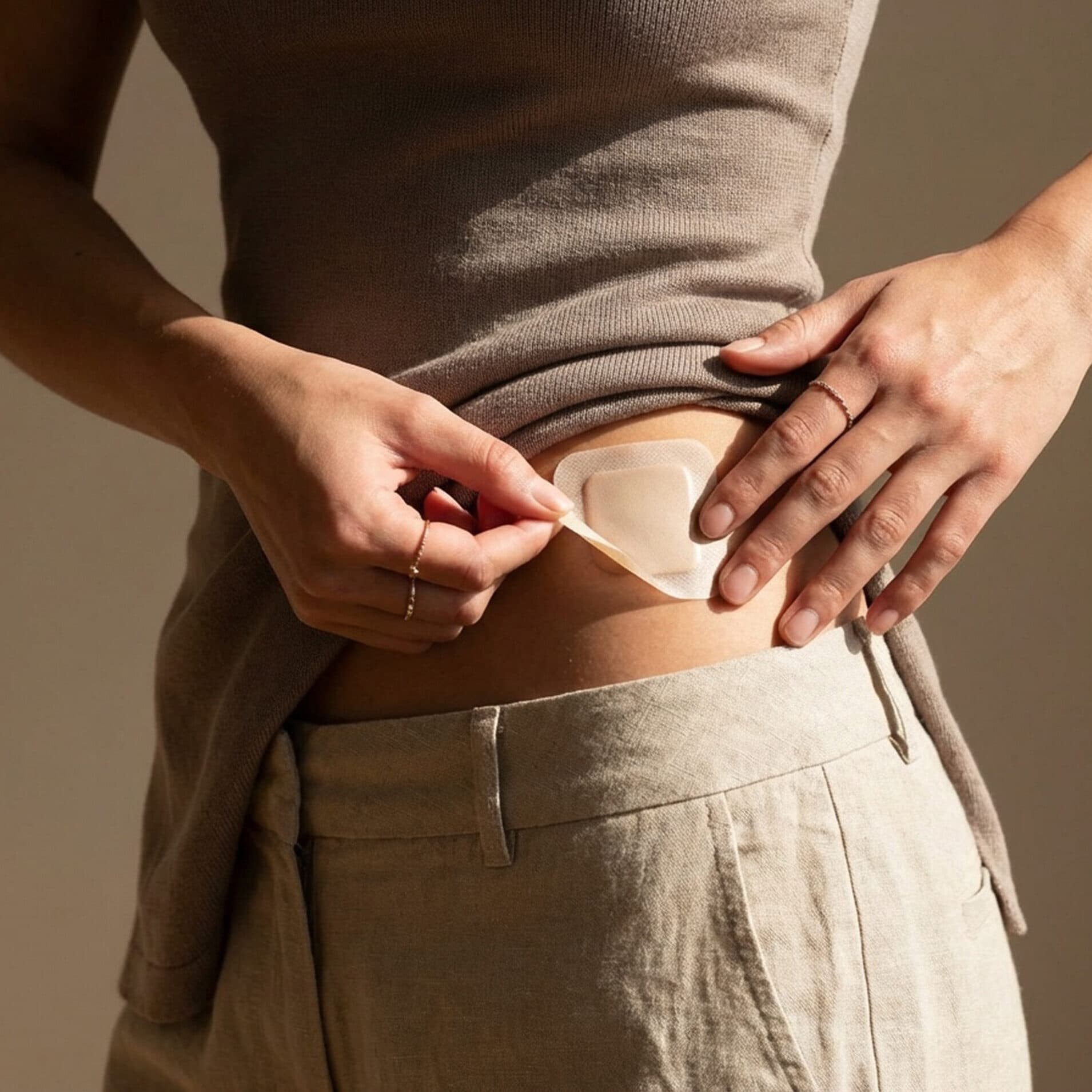 A person placing a patch on their hip